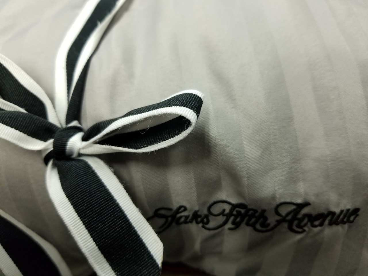 a black and white striped pillow with a bow