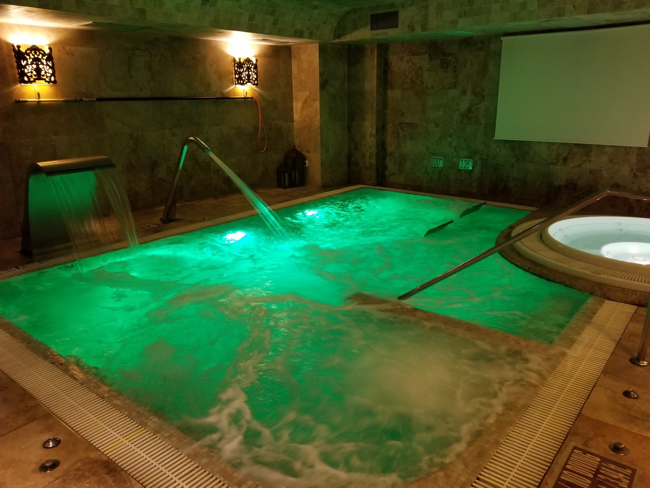 a large indoor hot tub with green lights