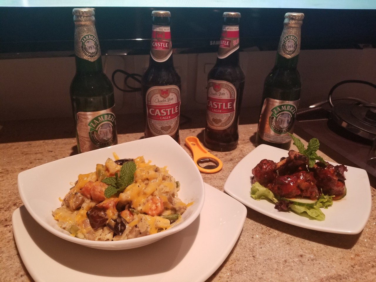 a plate of food and beer bottles on a counter