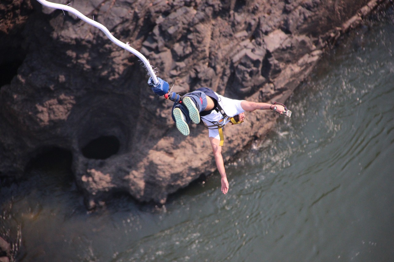 a man bungee jumping over water