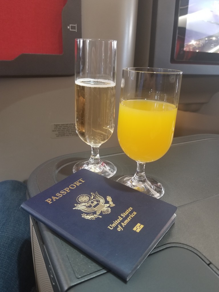 a passport and glasses of champagne on a table