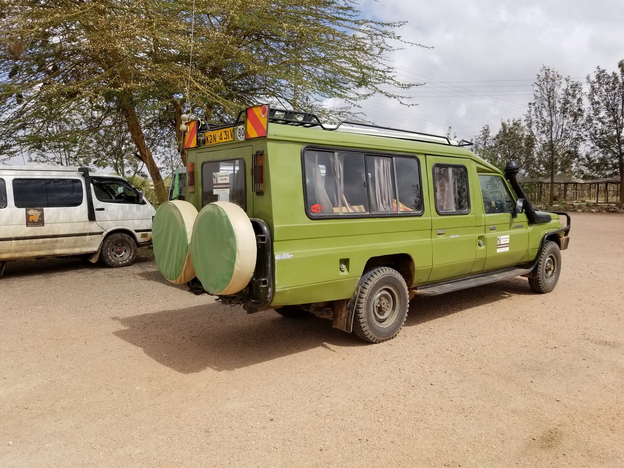 a green van with two spare tires on the back