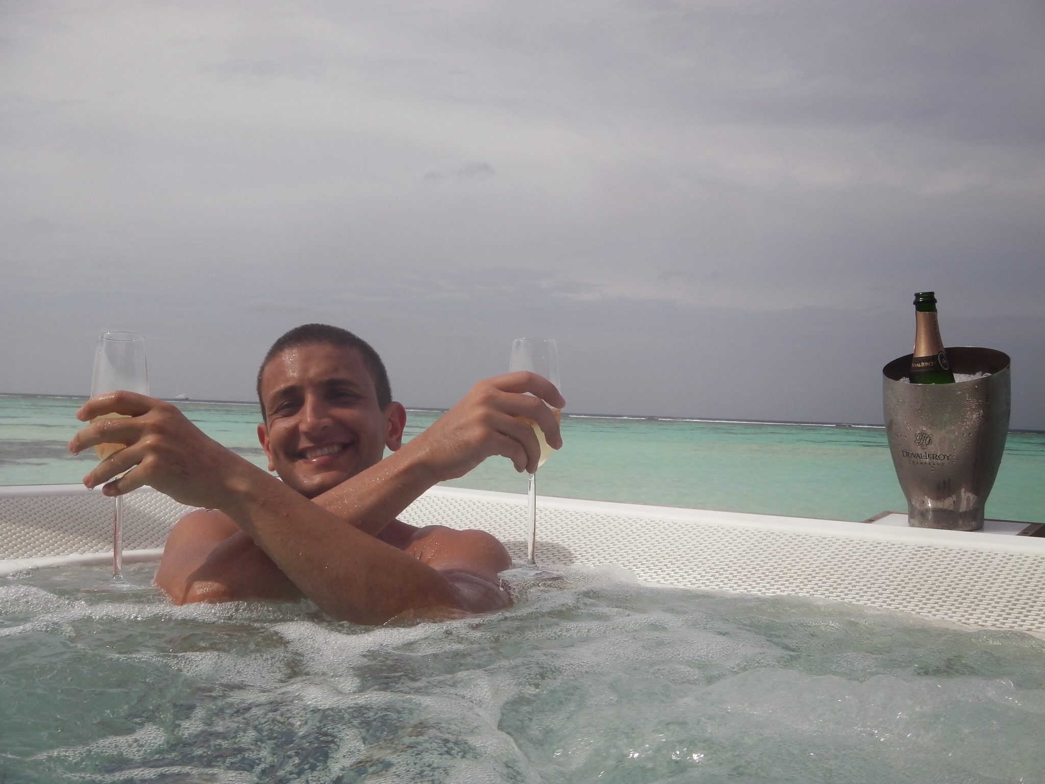 a man in a jacuzzi with a drink