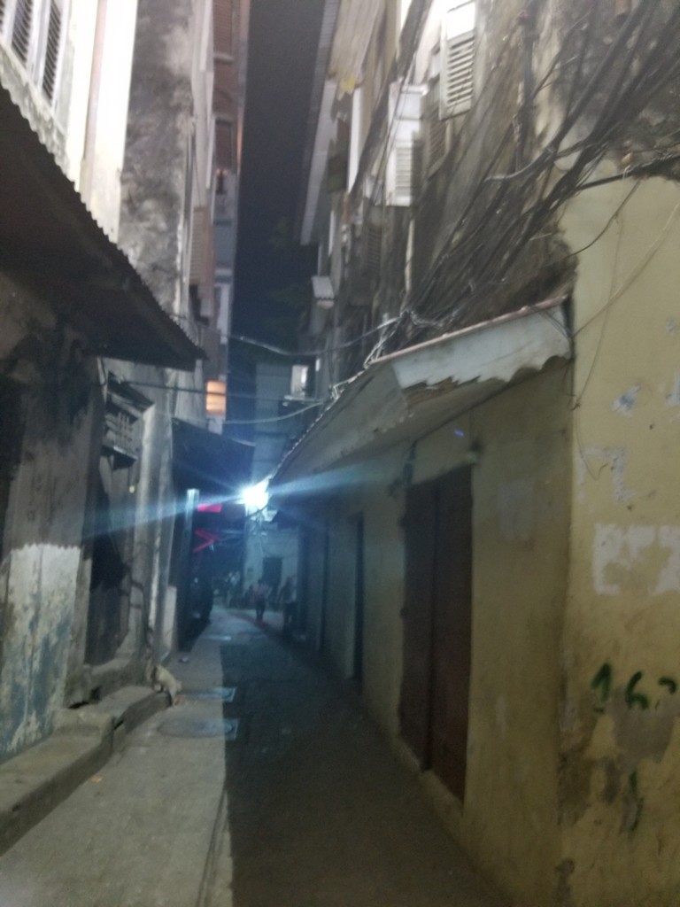 a narrow alleyway with a light shining on the side