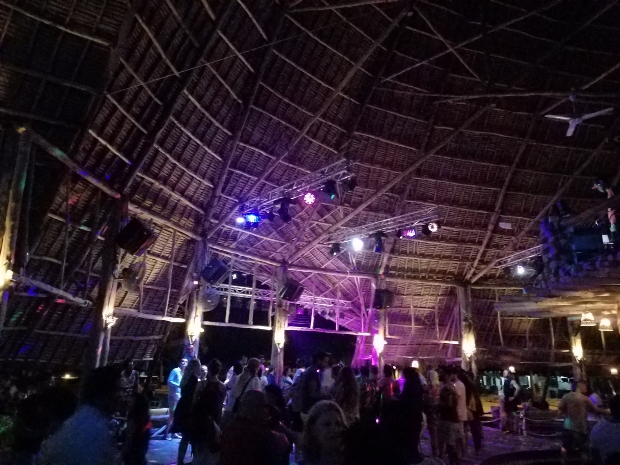 a large group of people in a room with a roof and lights