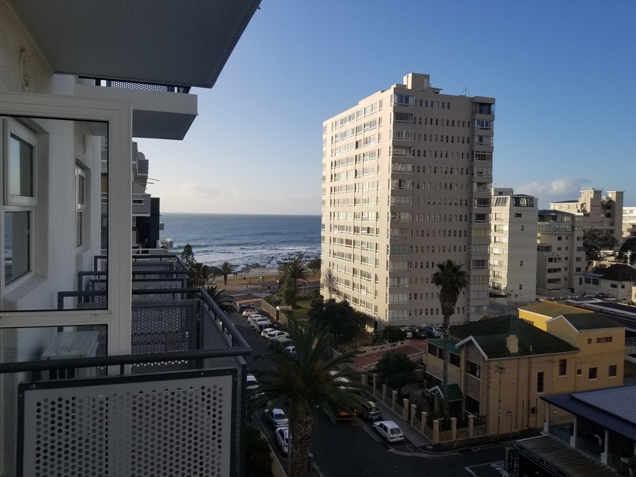 a view of a beach and buildings from a balcony