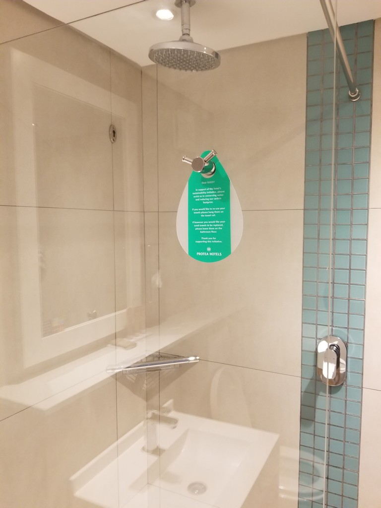 a shower with a green sign