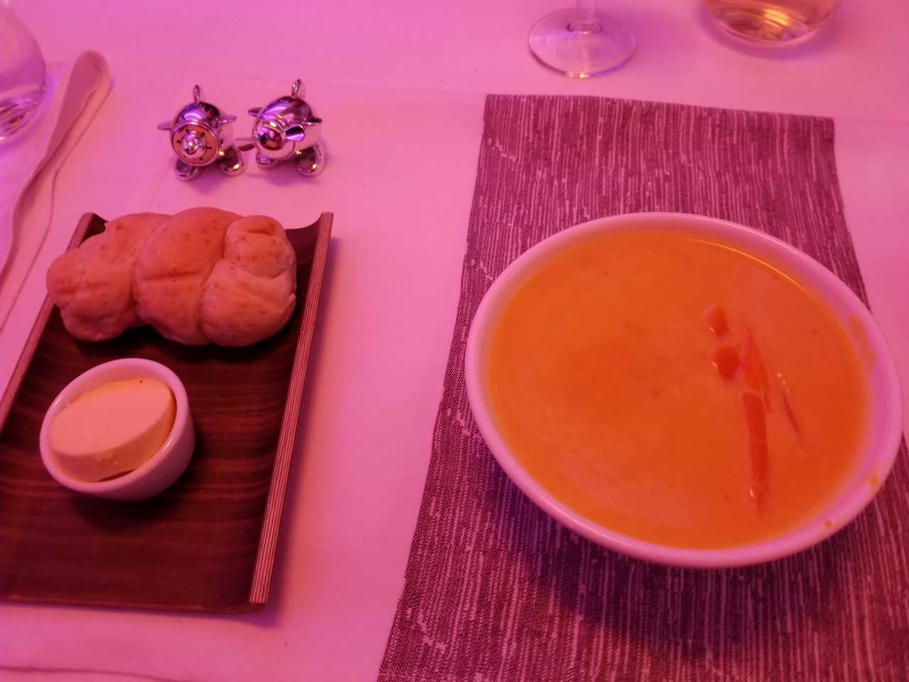 a bowl of soup and a plate of bread on a table