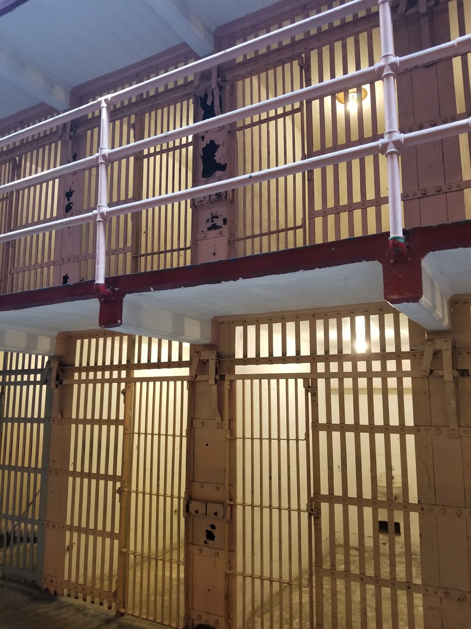 a prison cell with a balcony and railing