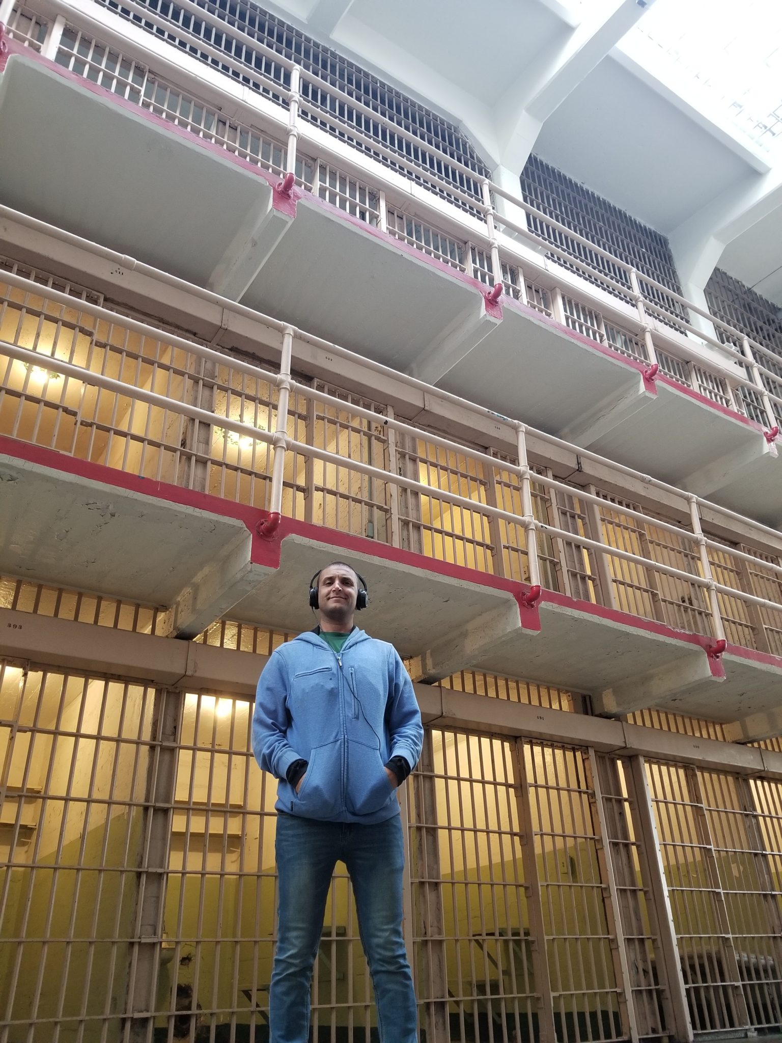 a man standing in front of a building with bars and windows