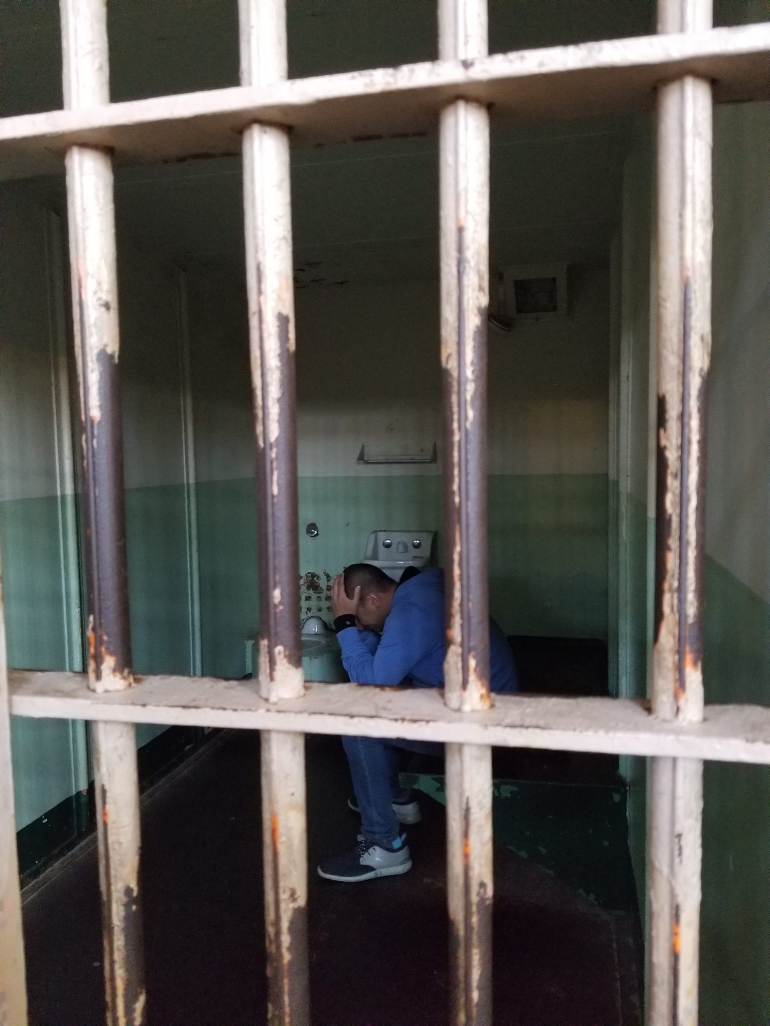 a man sitting in a jail cell