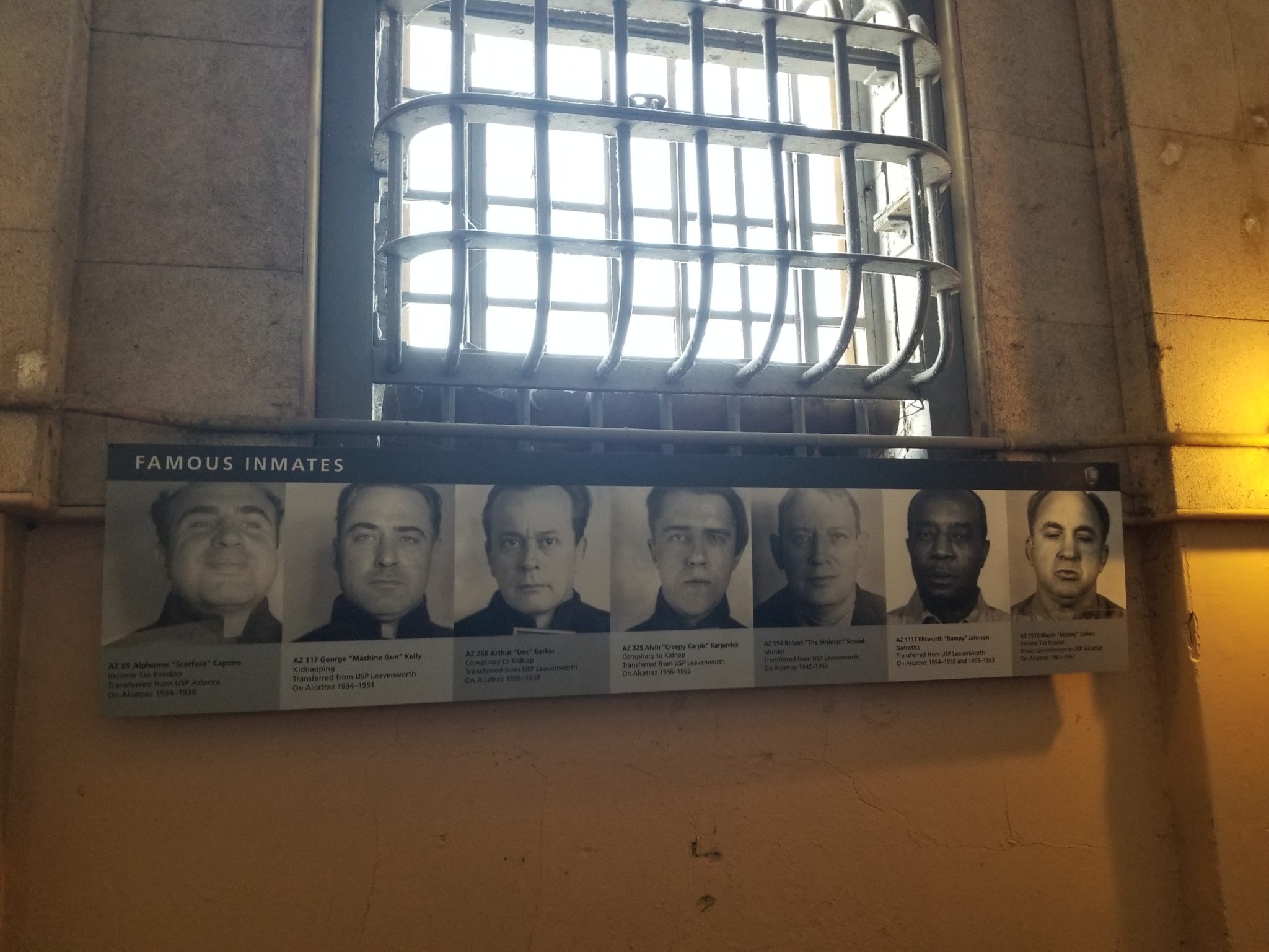 a prison window with bars and a sign with several images of men