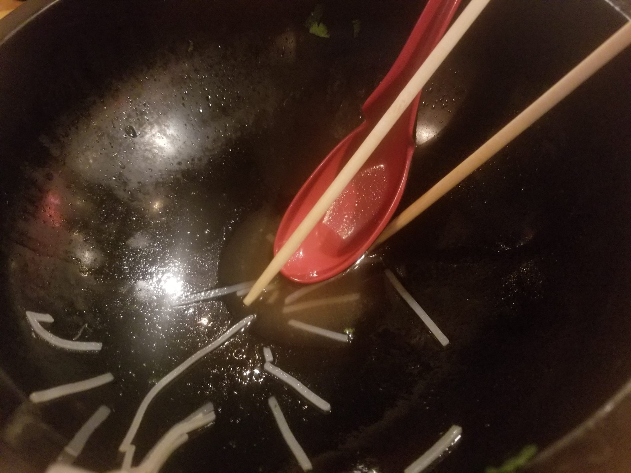 a bowl of noodles with chopsticks