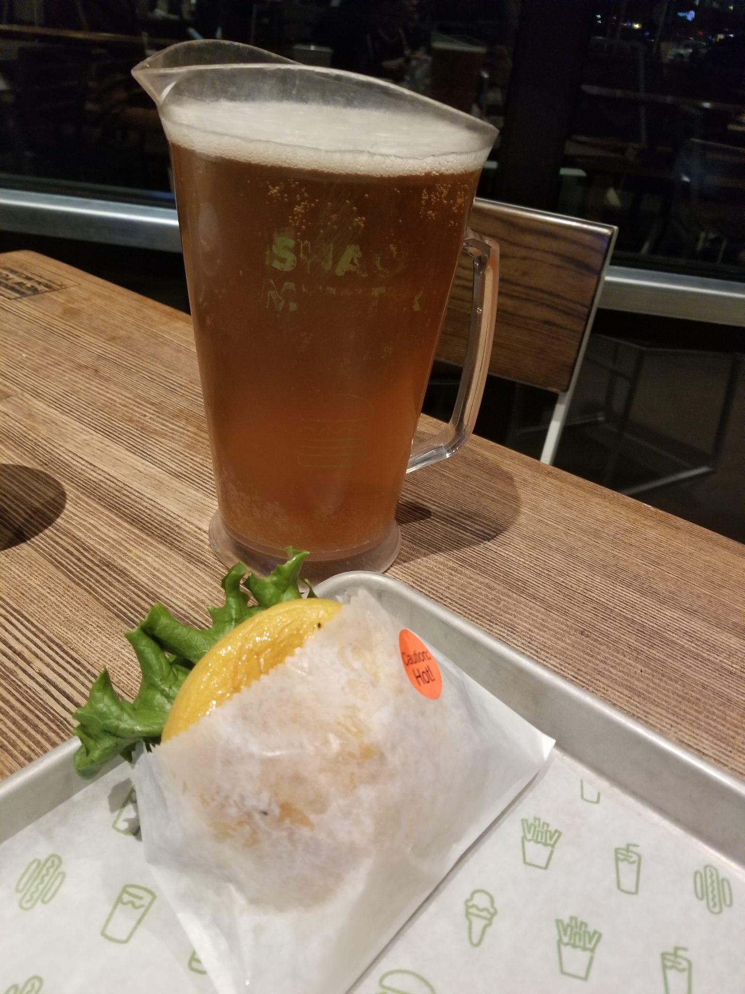 a glass of beer next to a sandwich