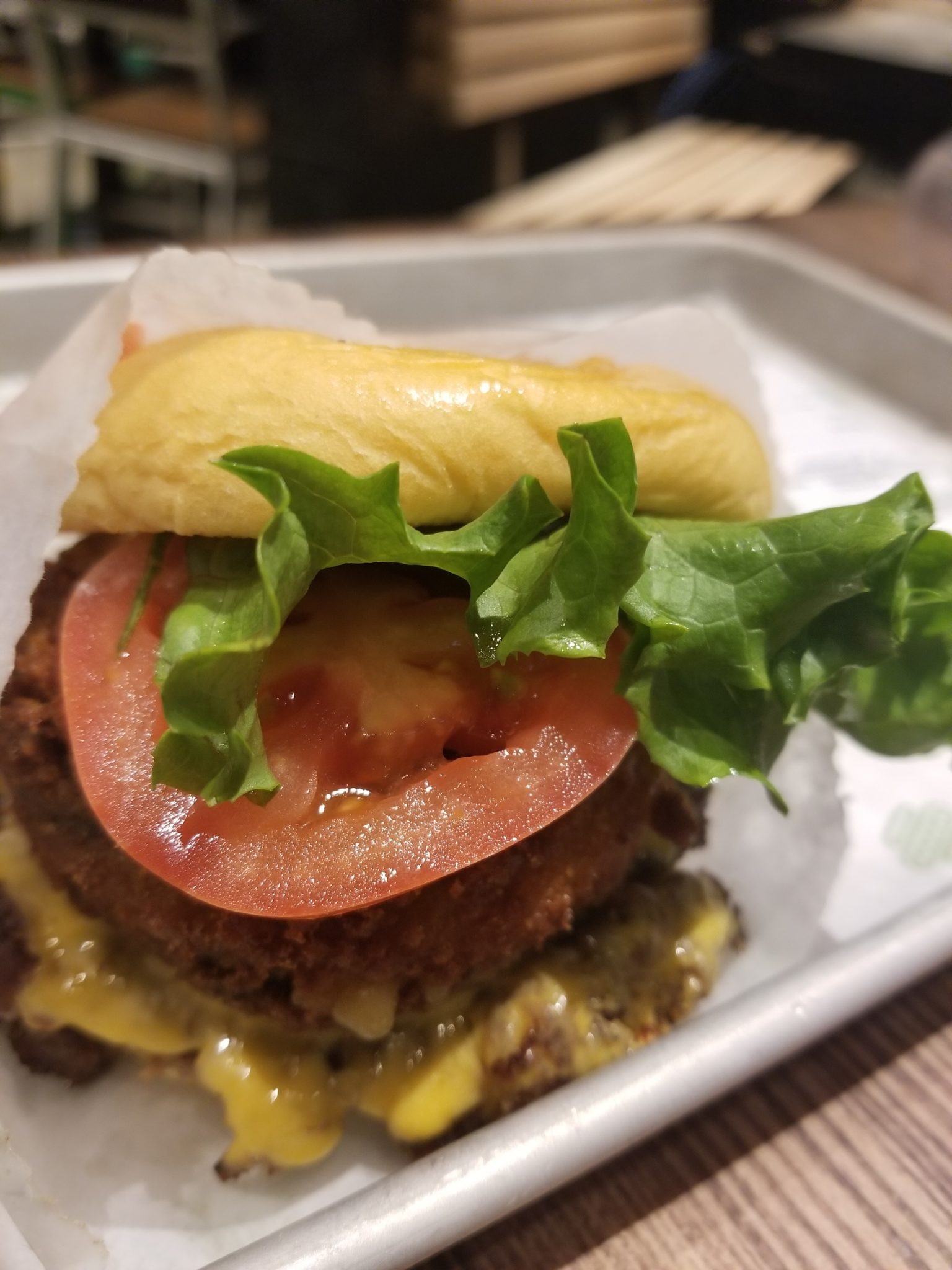 a burger with lettuce and tomato on a tray