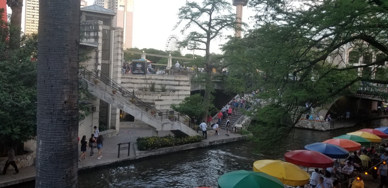 a group of people walking down stairs next to a river