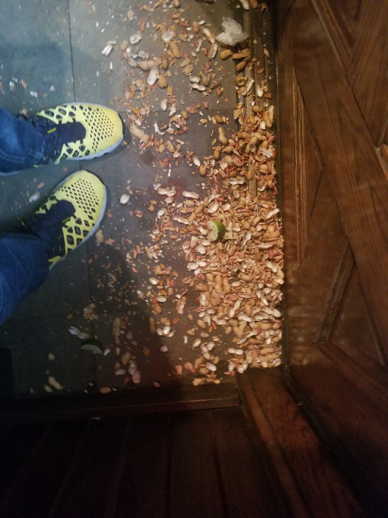 a person's feet on a floor with food on the floor