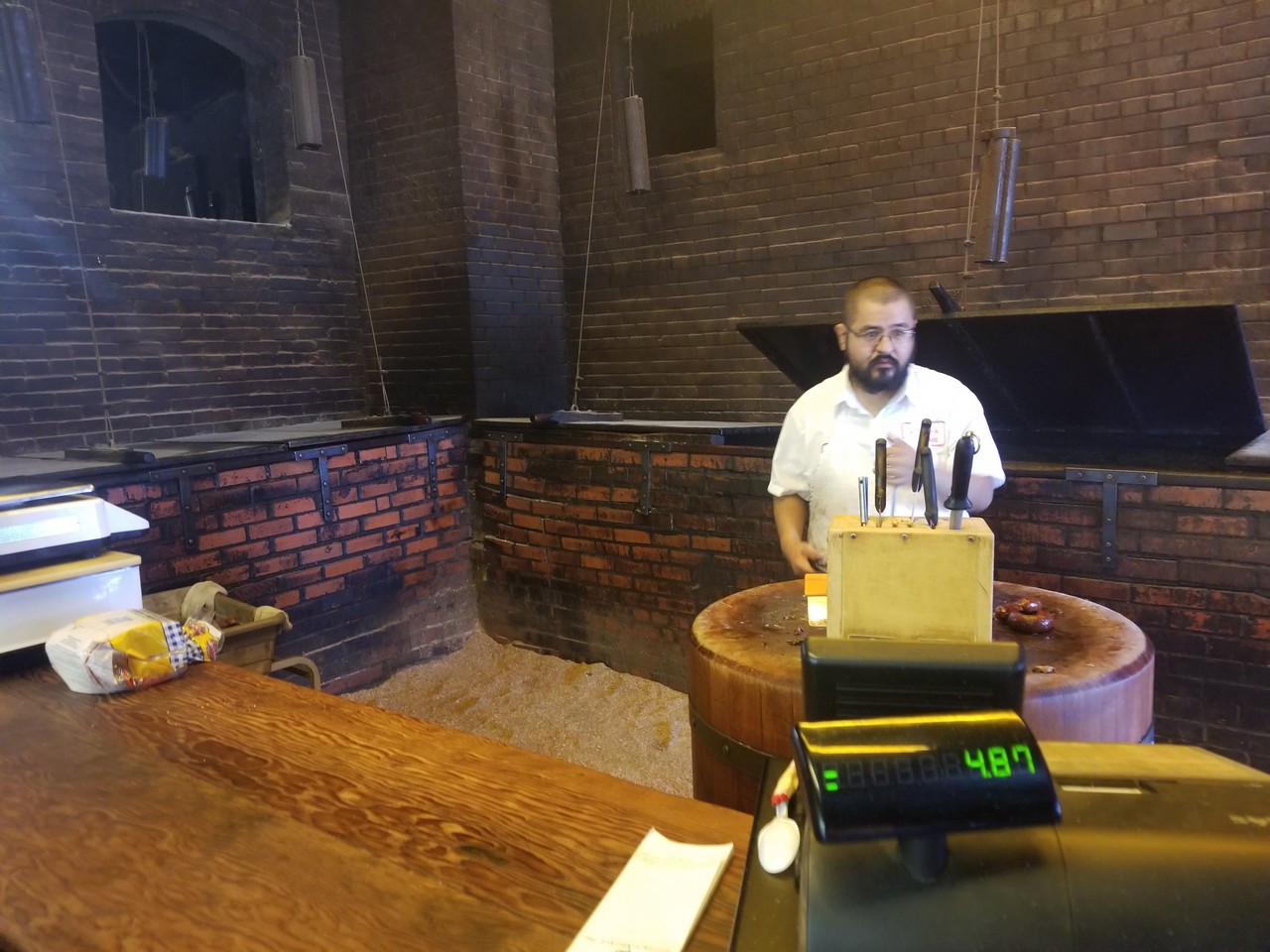 a man standing behind a counter in a brick room