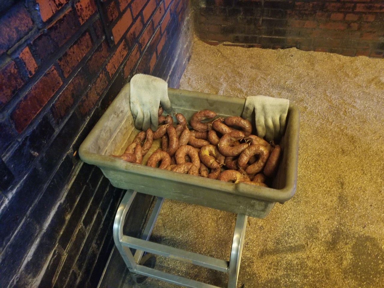 a person holding a tray of sausages