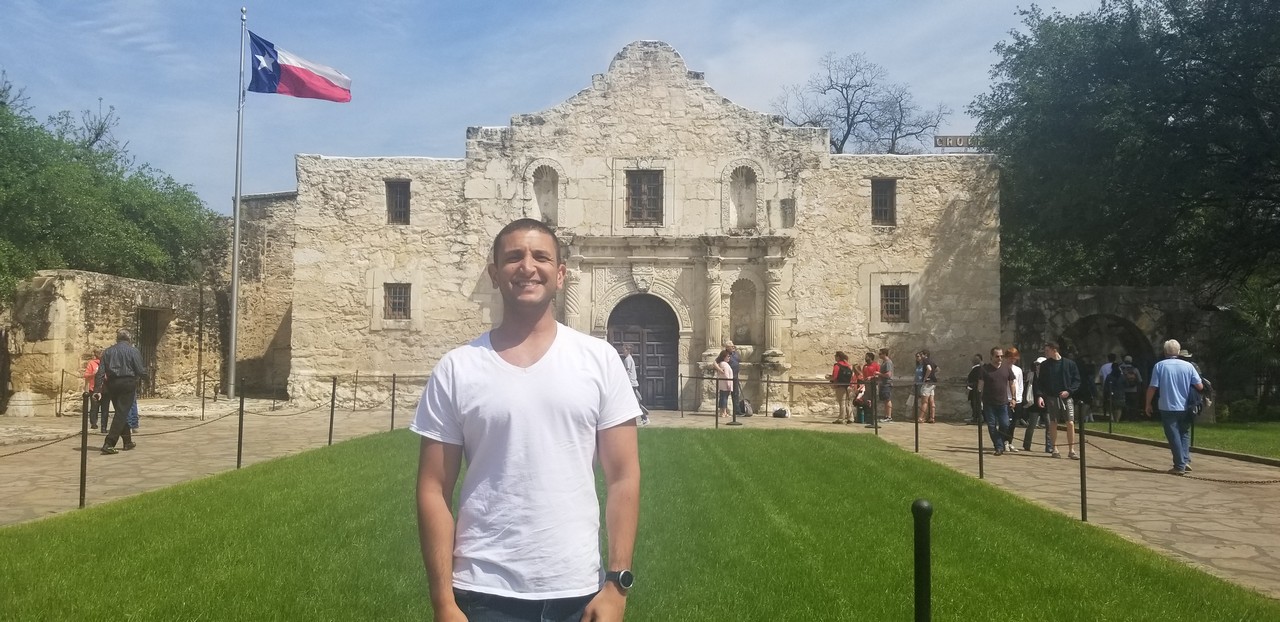 a man standing in front of Alamo Mission in San Antonio
