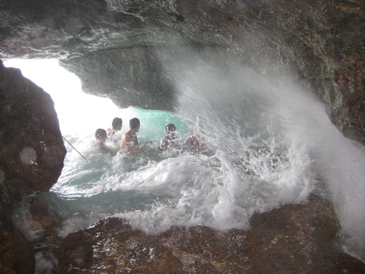 a group of people swimming in a cave