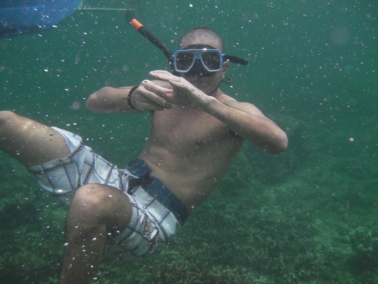 a man wearing goggles and snorkeling underwater
