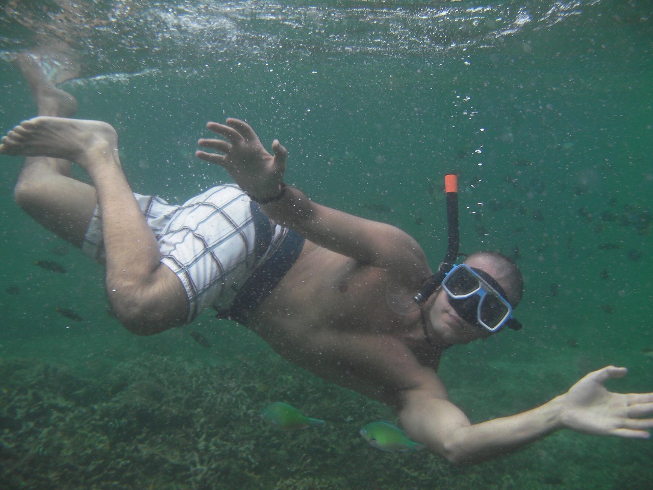 a man wearing goggles and diving underwater