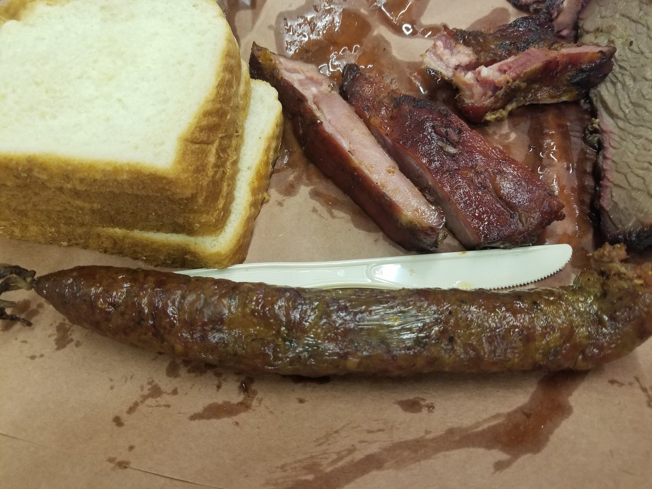 a sausage and ribs on a paper