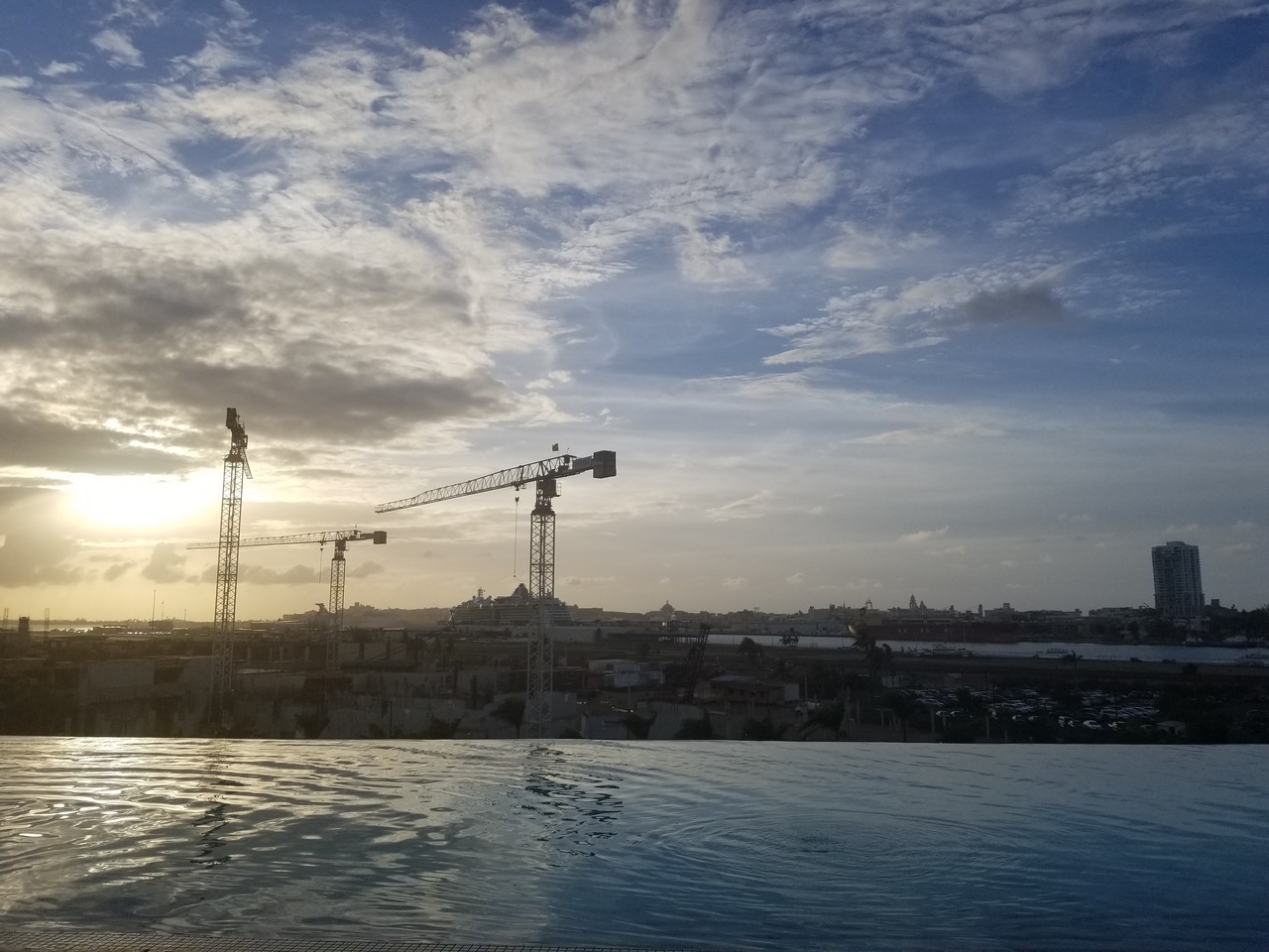 a pool with cranes in the background