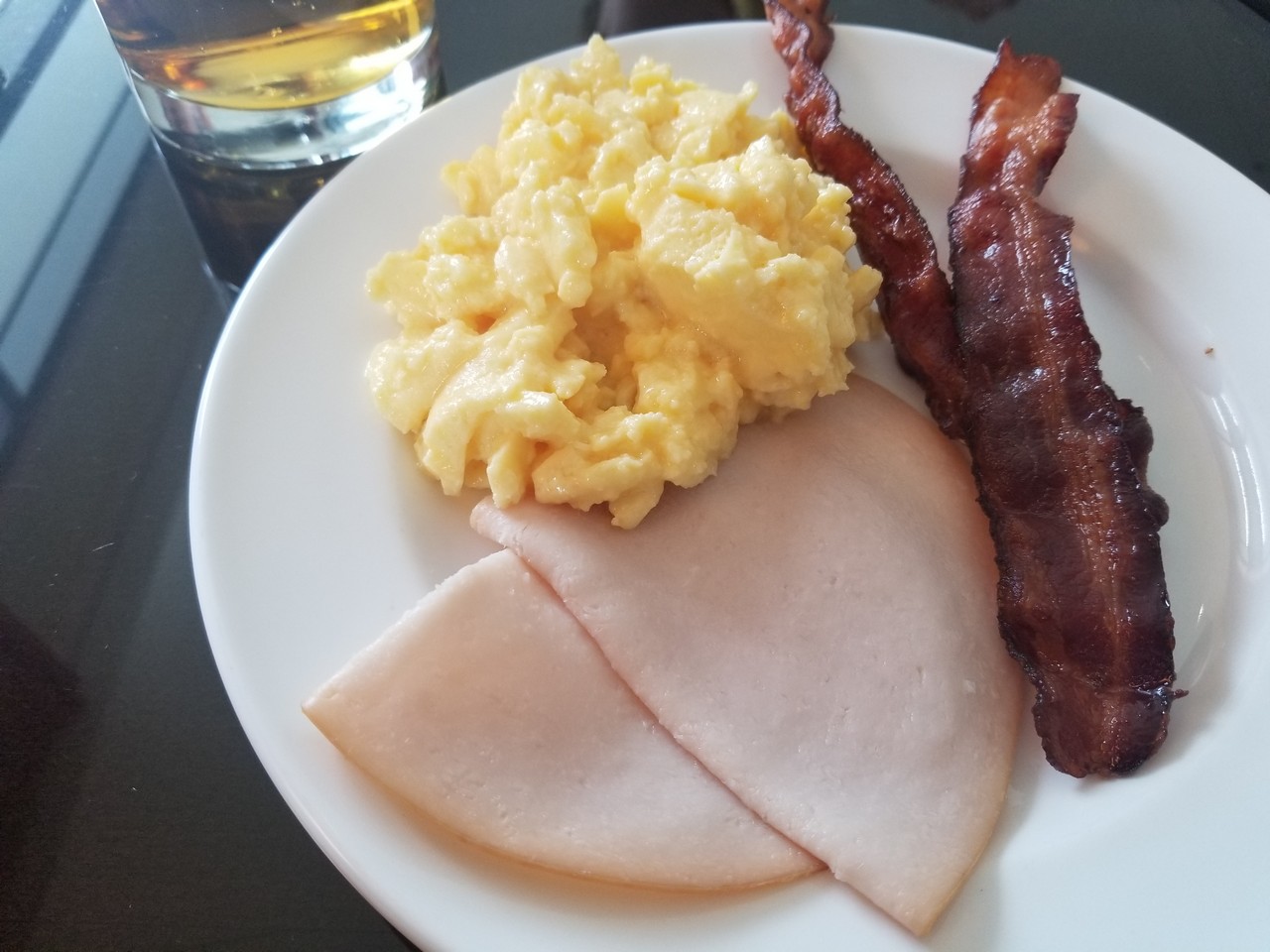 a plate of food with bacon and eggs