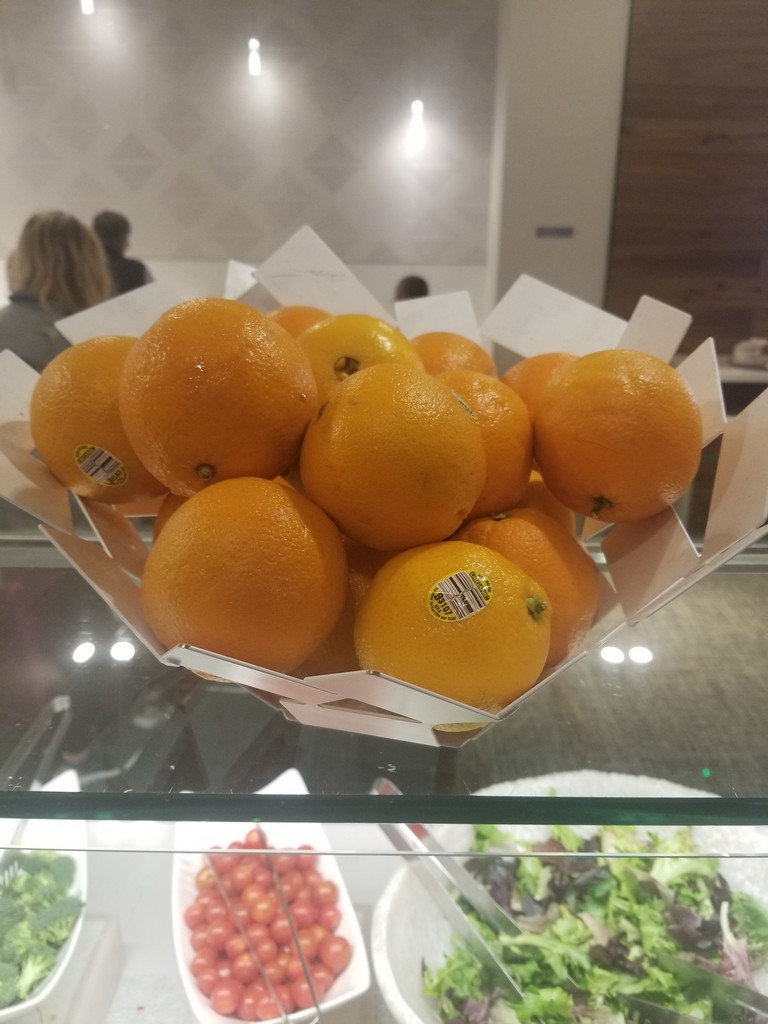 a bowl of oranges on a glass shelf
