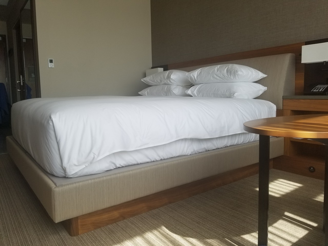 a bed with white sheets and a table