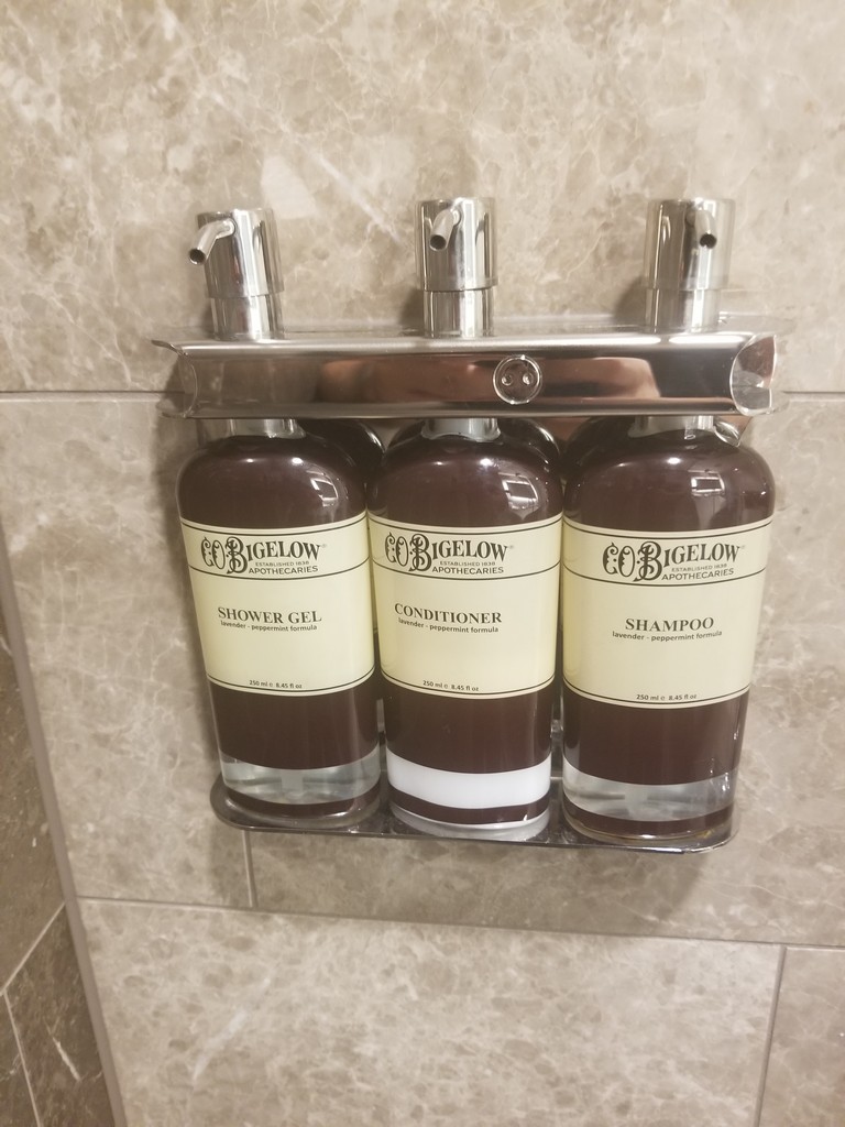 a group of shampoo bottles on a metal shelf