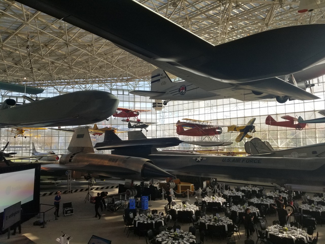 a group of people in a room with airplanes and tables