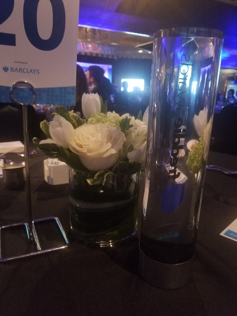 a vase with flowers and a name tag on a table
