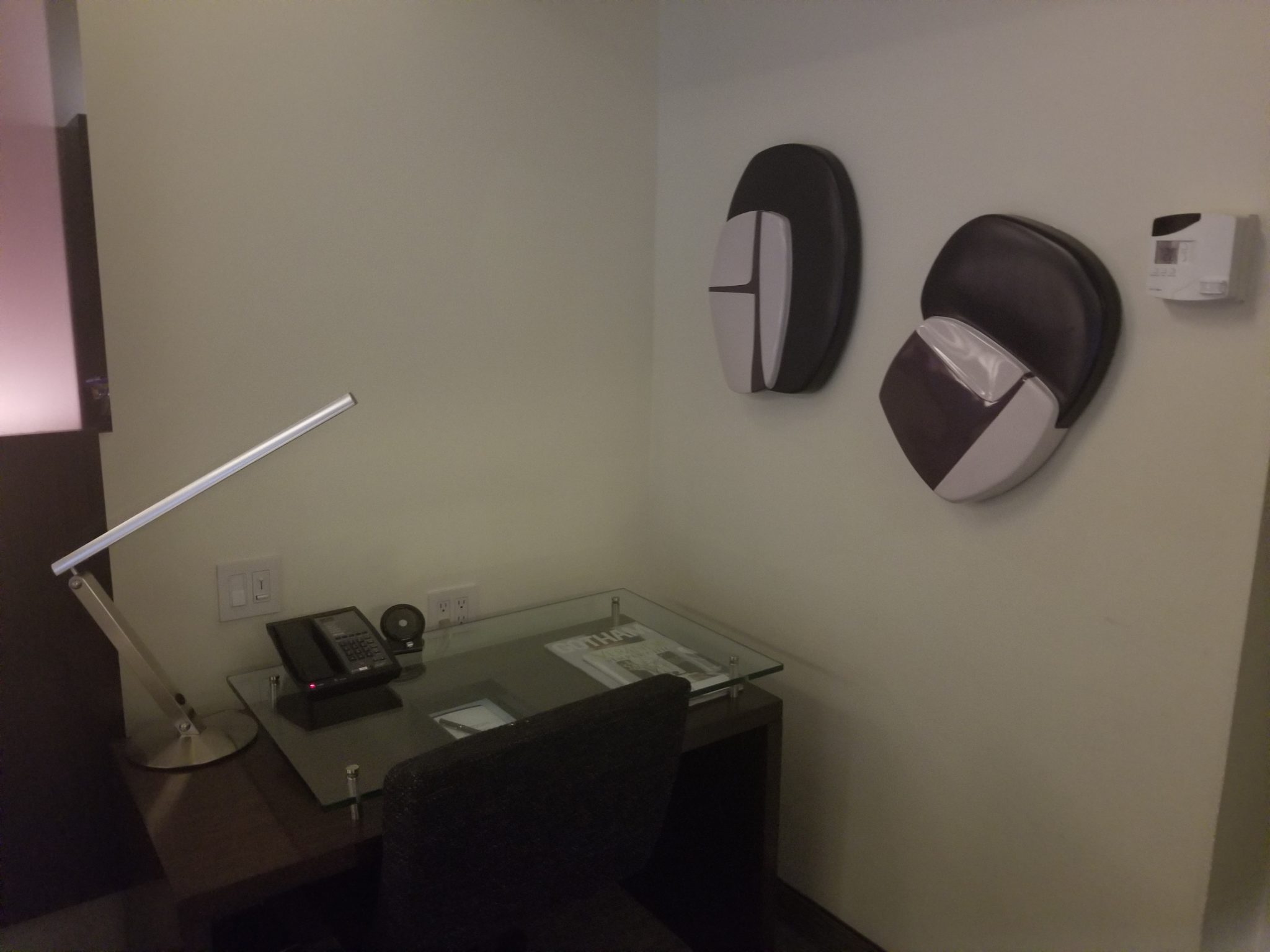 a desk and chair with a phone and a telephone on the wall