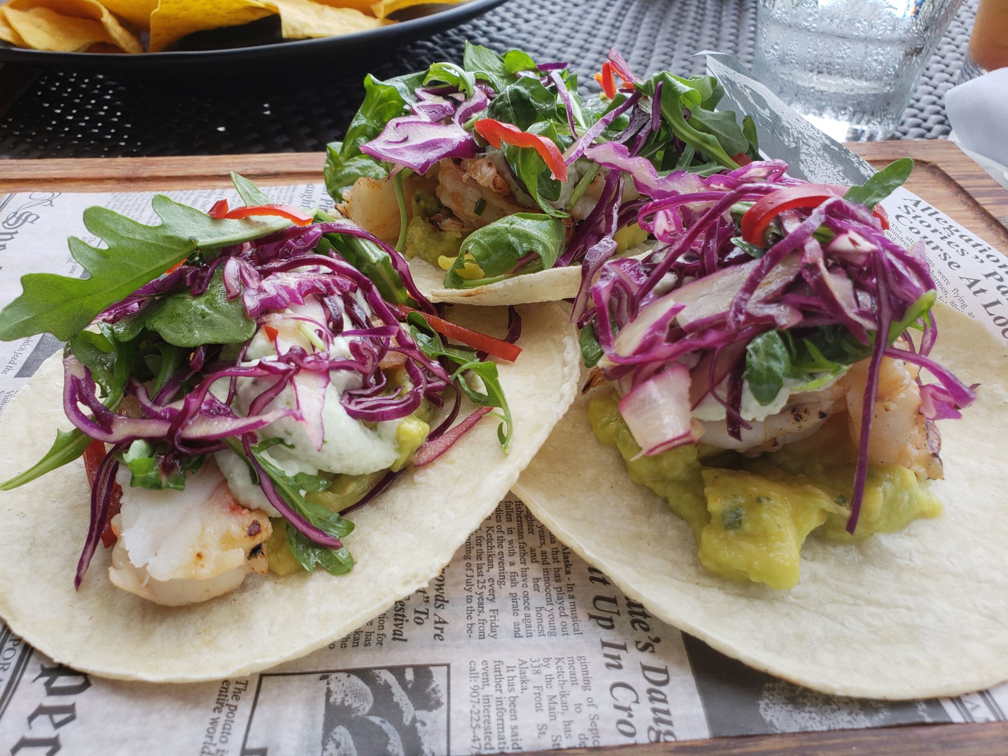 a group of fish tacos on a newspaper