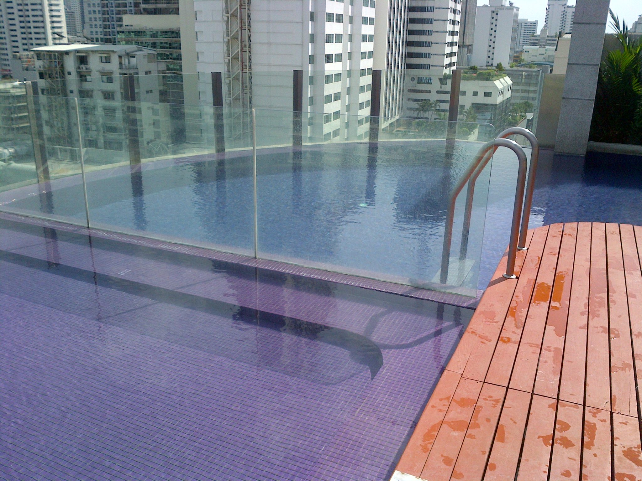 a pool with a railing and a wood deck