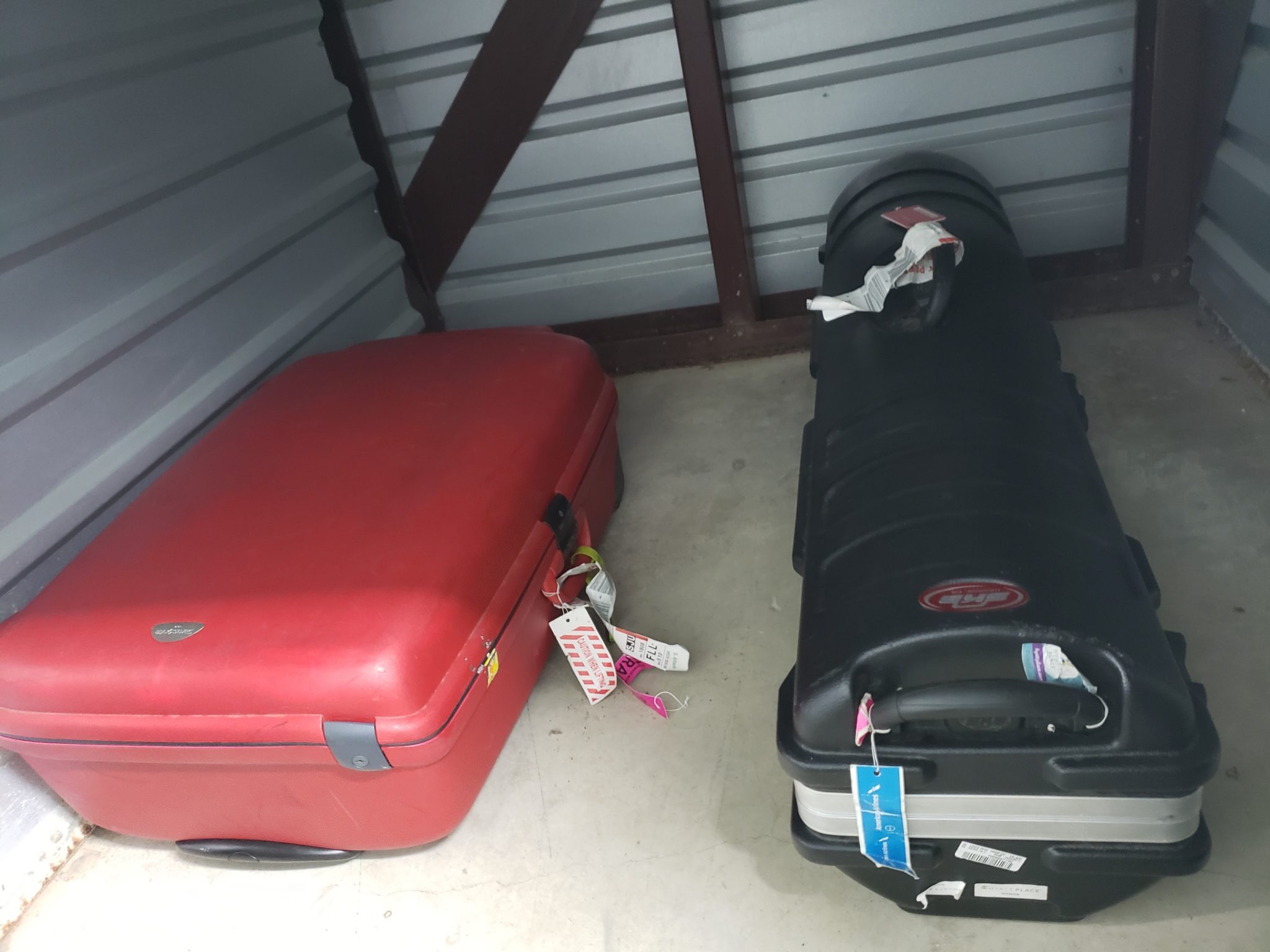 a red and black suitcases in a storage room