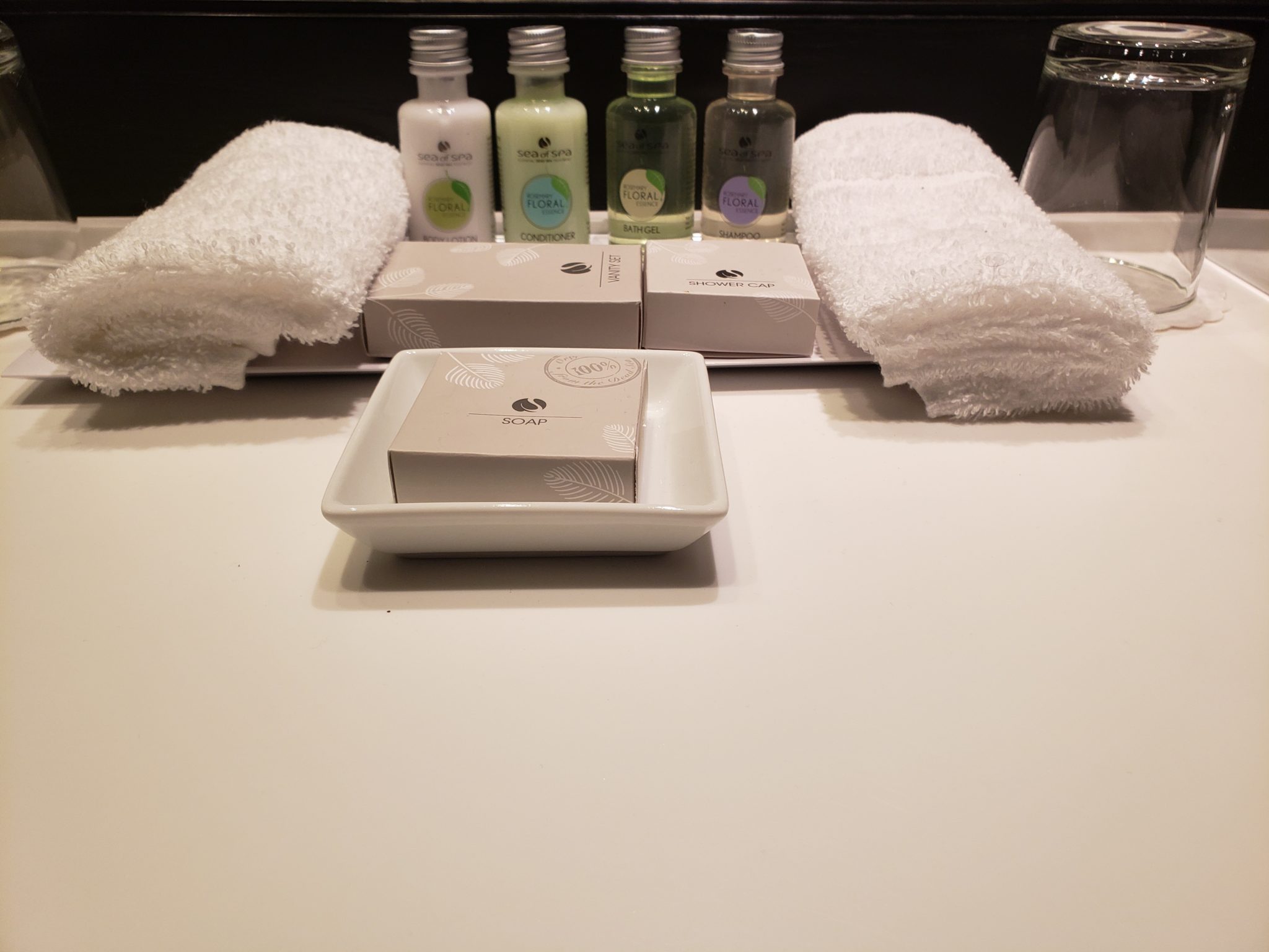 a group of small bottles of soap and towels on a white surface