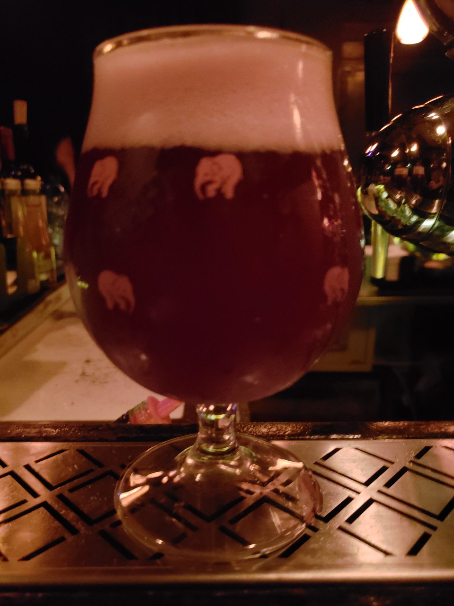 a glass of beer with elephants on it
