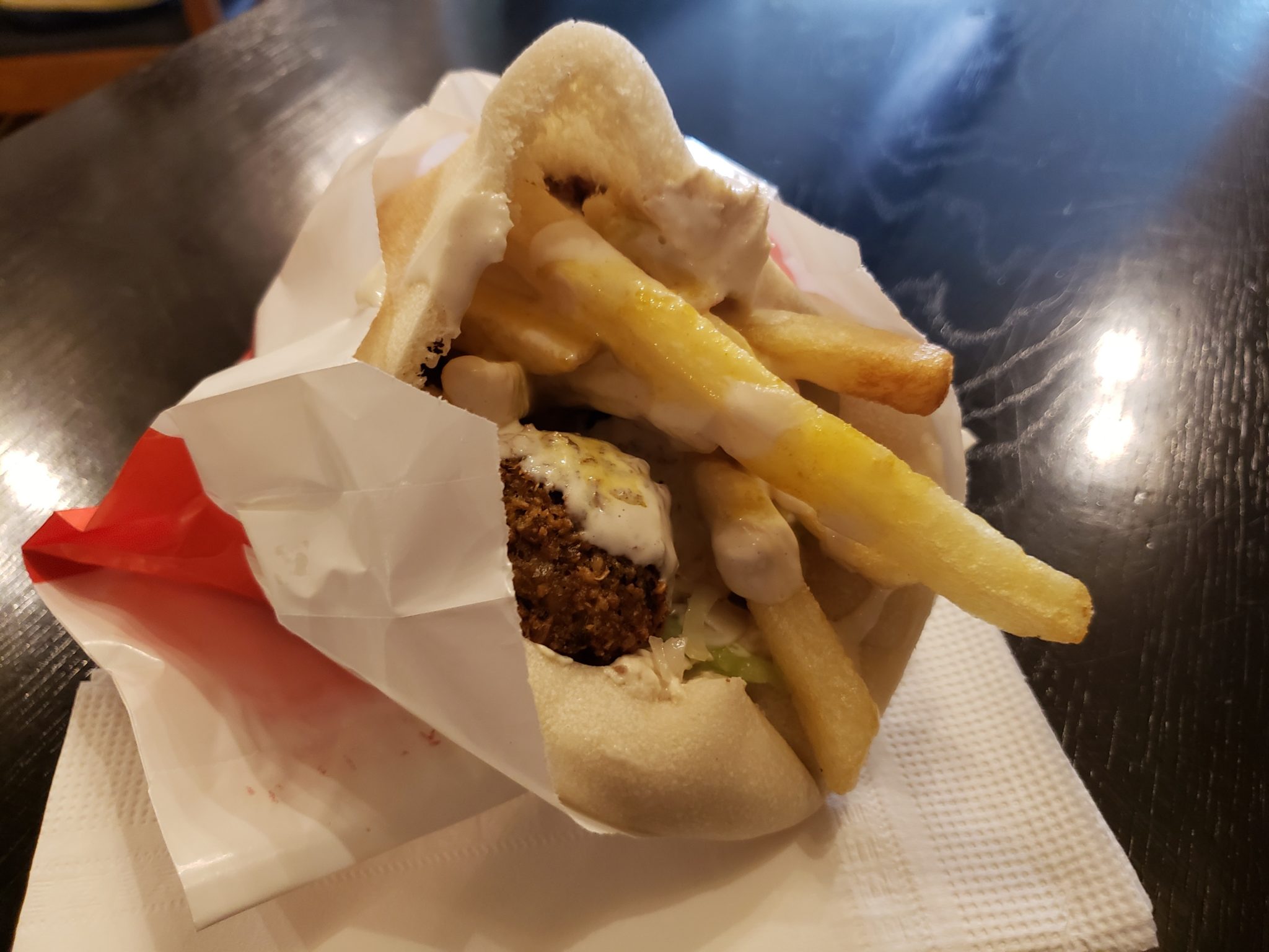 a pita with fries and meatball inside