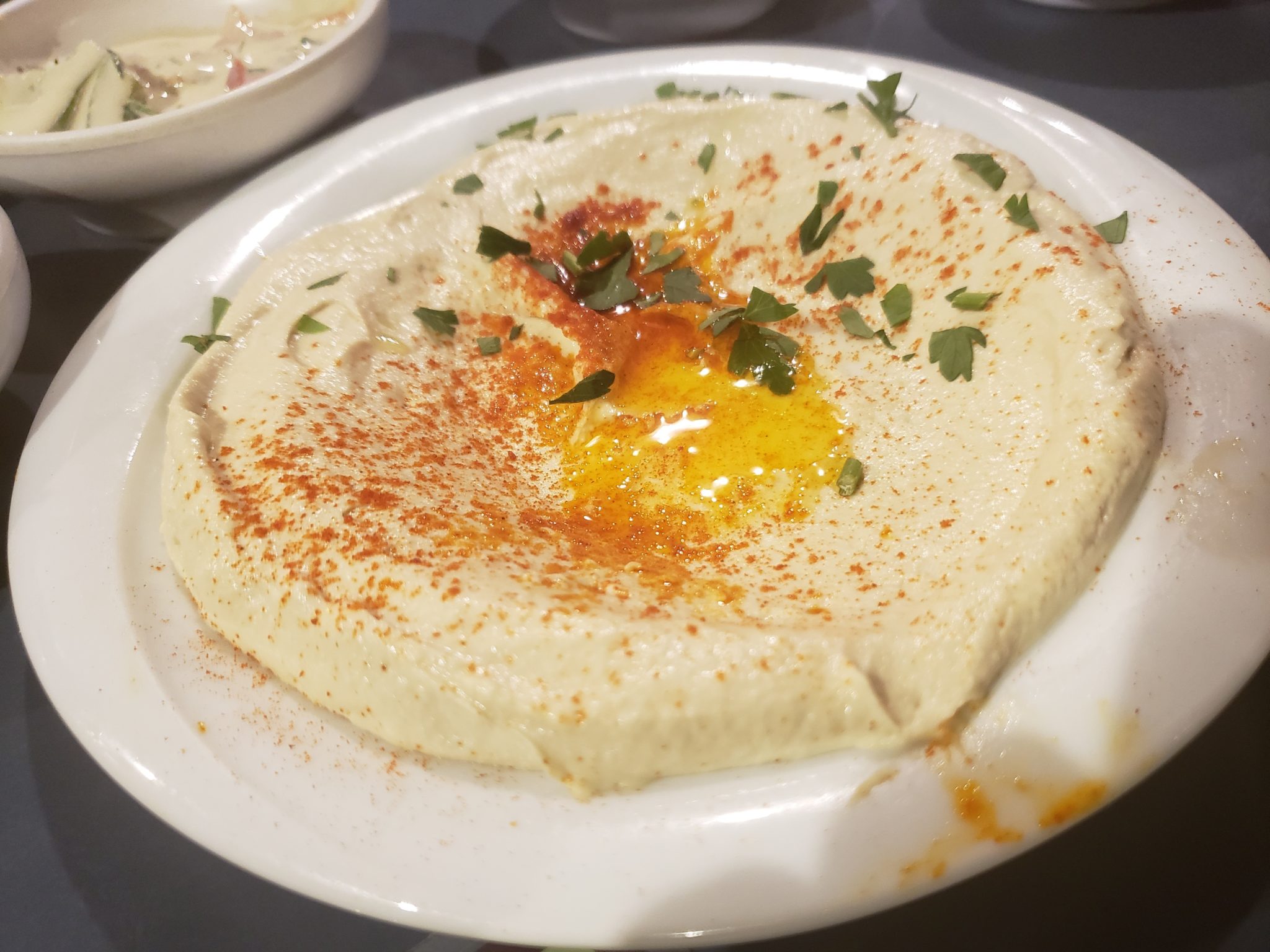 a plate of hummus with spices on it