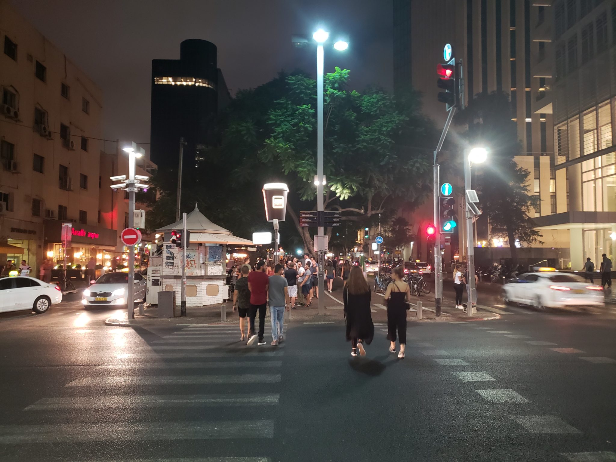 a group of people crossing a street at night