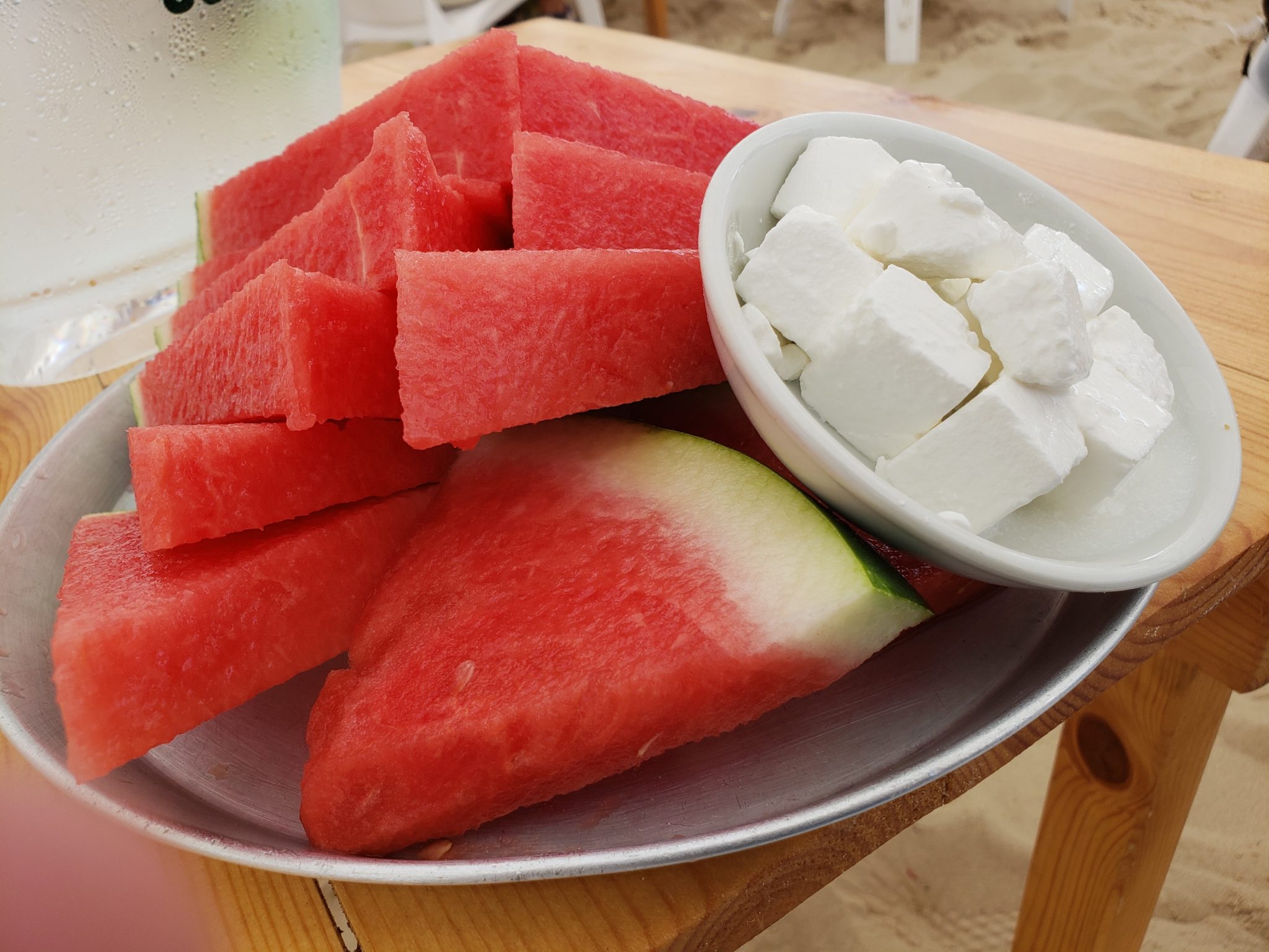 a plate of watermelon slices and white cheese