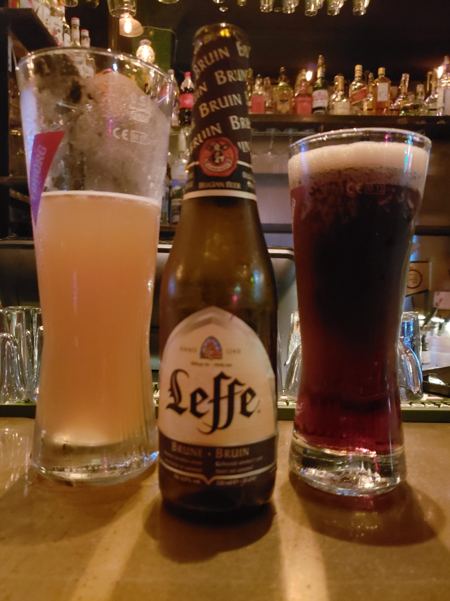 a bottle of beer next to a glass of beer