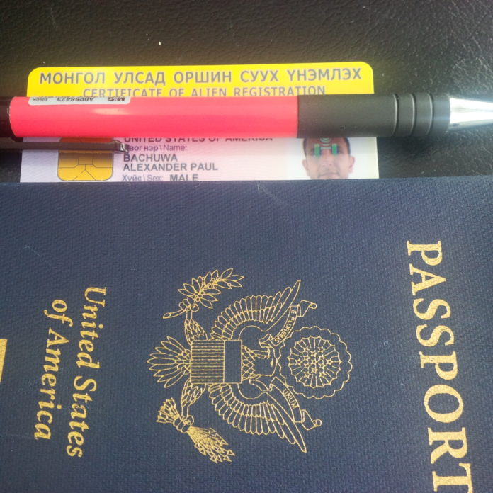 a passport and a pen on a table