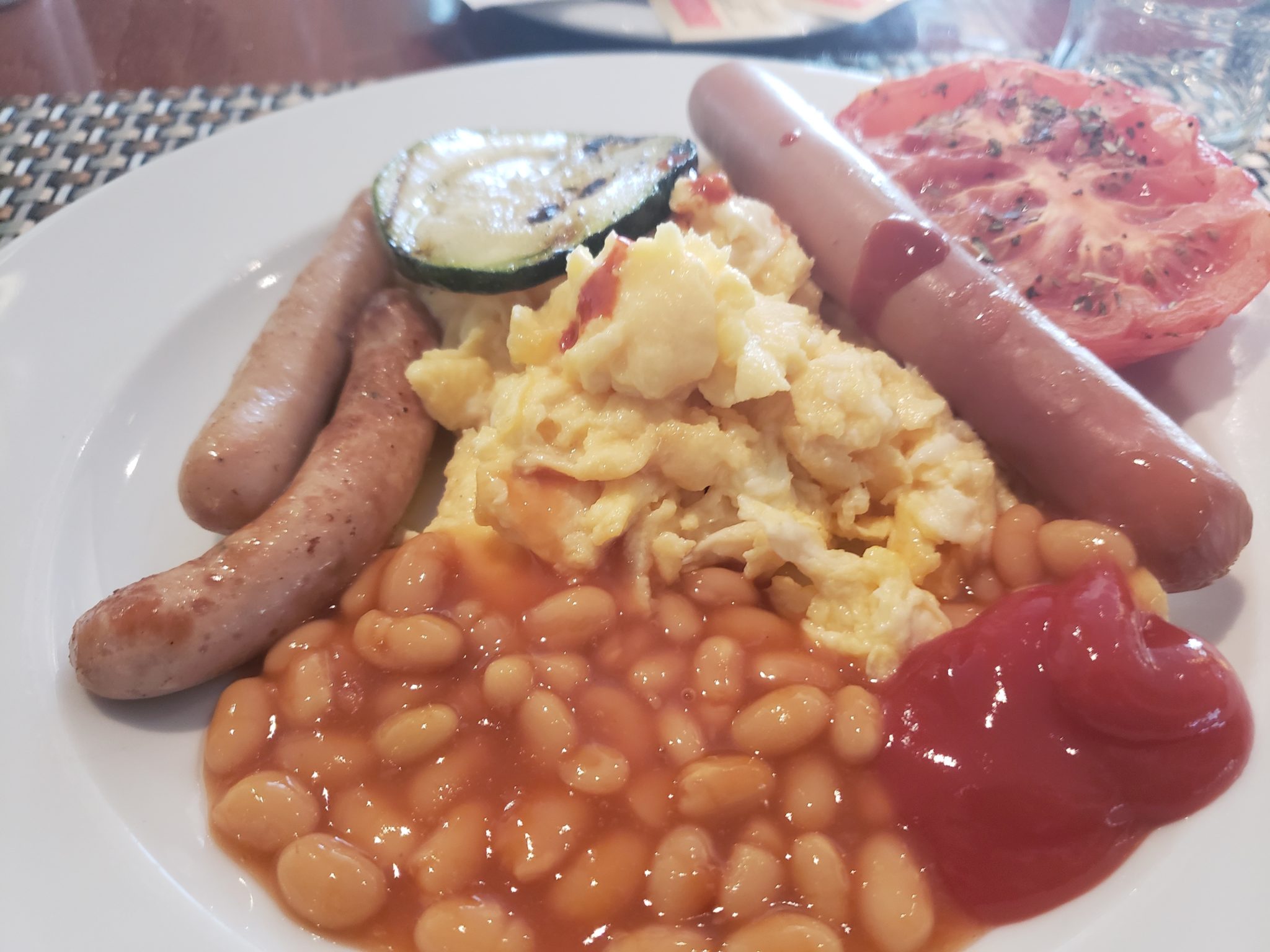 a plate of food with sausages beans and tomatoes