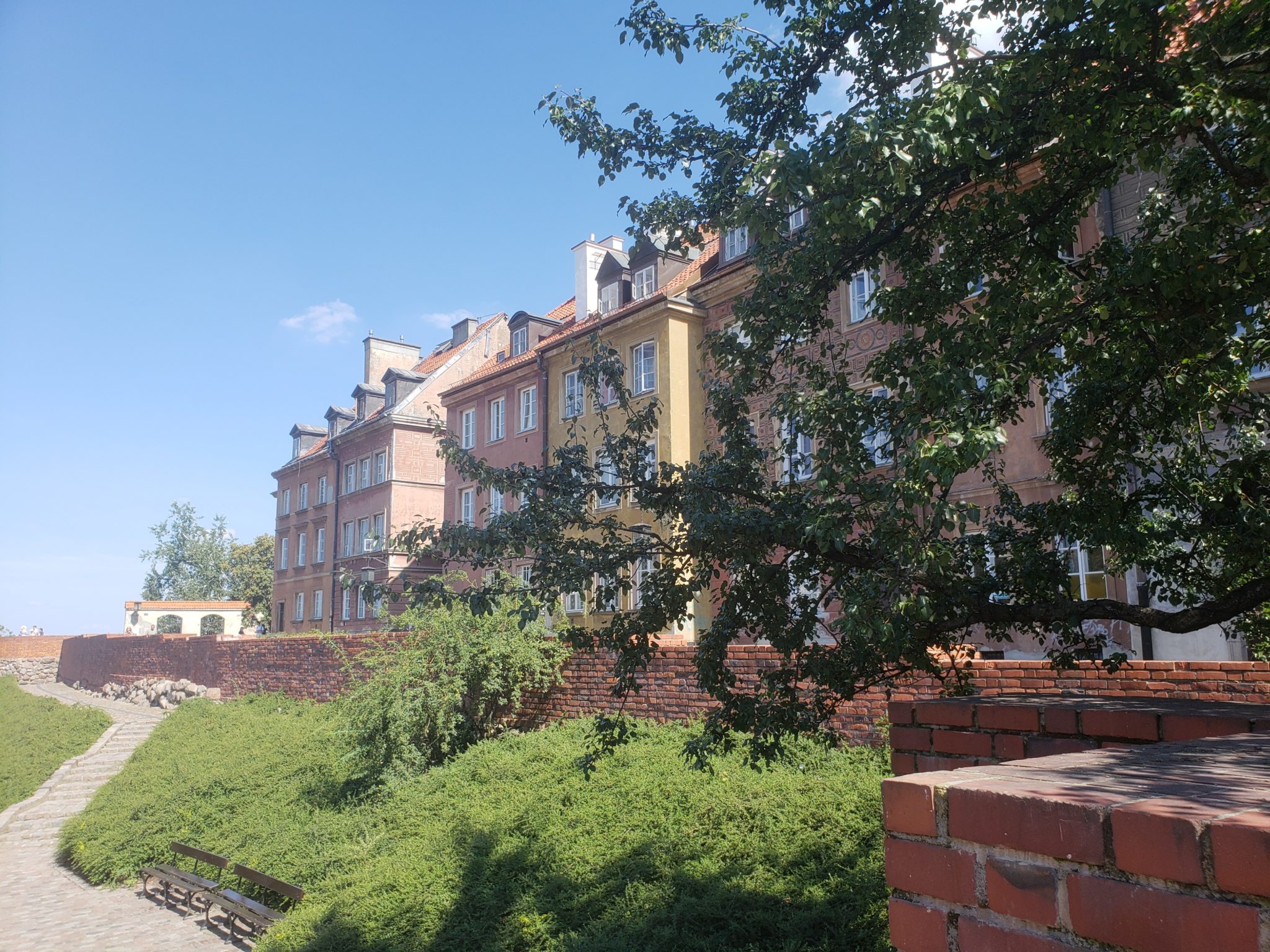 a brick building with trees and bushes