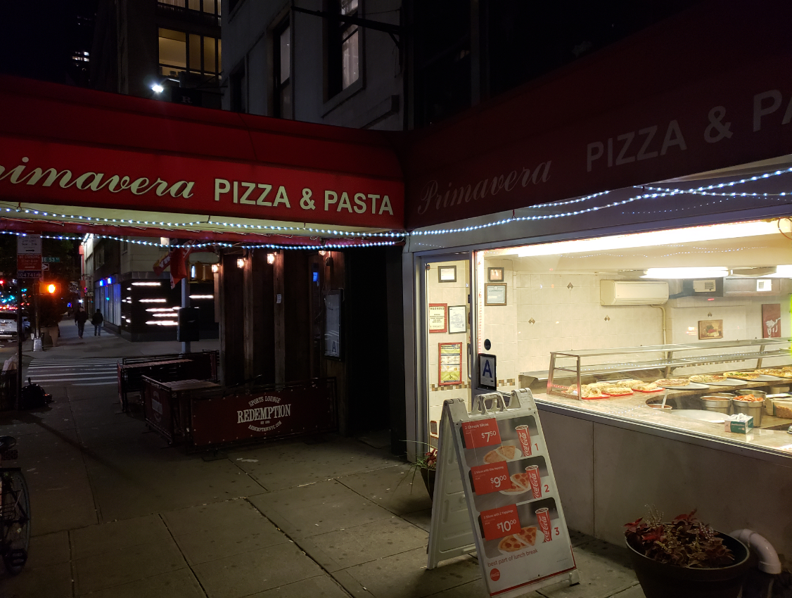 a pizza stand outside of a restaurant
